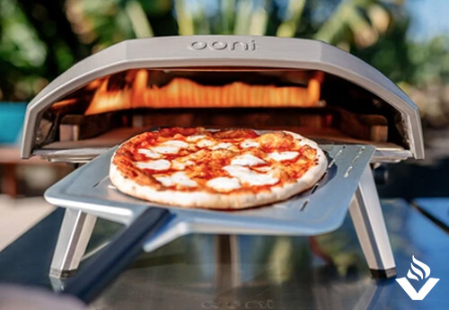 A stone-baked margherita pizza comes out of the hot Ooni Koda pizza oven