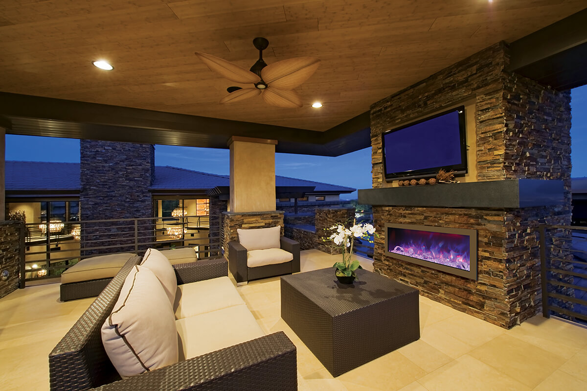 A TV sits above an electric fireplace in this outdoor patio 